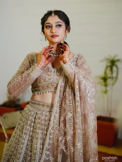 A candid moment of the bride getting ready. Her makeup is almost complete, and she looks absolutely stunning.