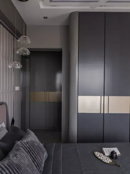 Sophisticated and timeless, this master bedroom is a seamless fusion of luxury and functionality. The deep-toned wardrobes with gold accents create a bold, elegant statement, while the textured paneling adds depth and character.