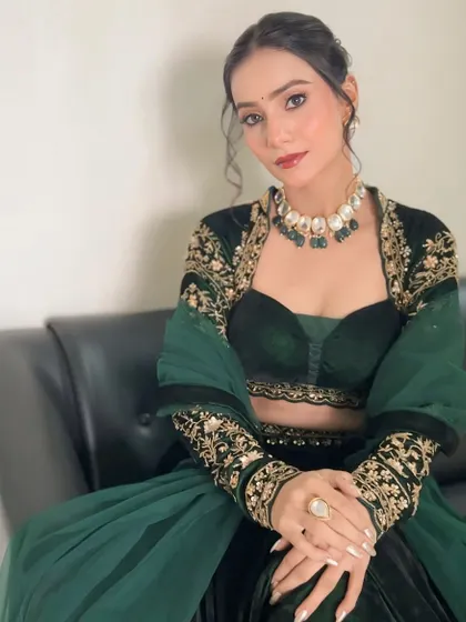 A seated portrait showing the intricate embroidery on the jacket and the beautiful harmony between the makeup and the outfit.