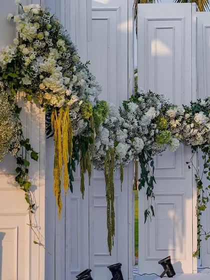 The full sweep of the floral garland across the entrance doors. This grand gesture created a stunning first impression for guests arriving at the wedding.