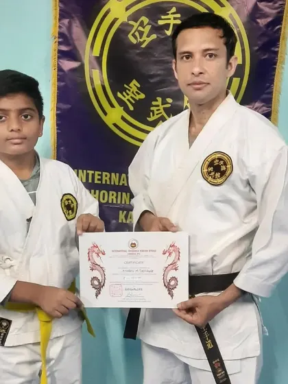 I congratulate a young student on successfully passing his Kyu grading. Advancement is a direct result of dedication and hard work, and I formally recognize every student's progress with certified ranking.