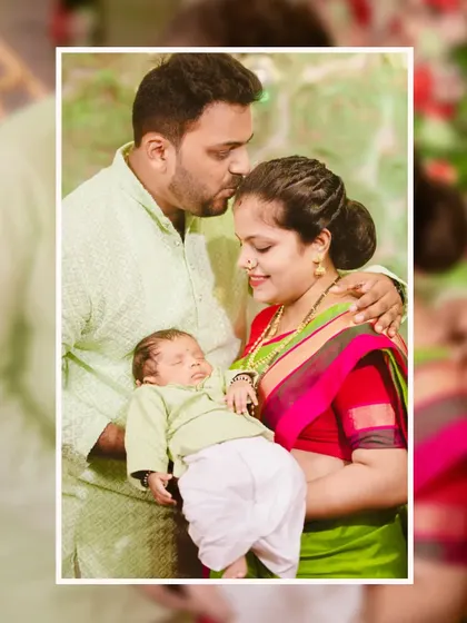 A beautiful family portrait showing a father kissing his newborn's forehead as the mother looks on with love.