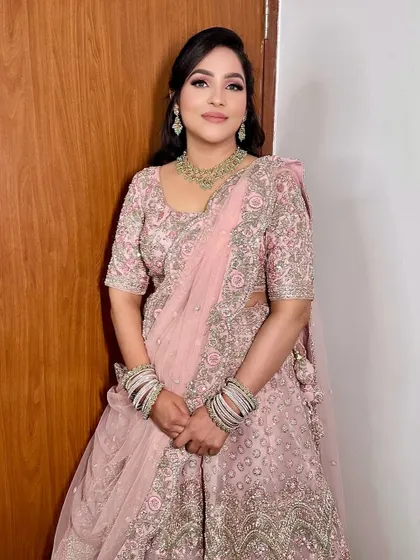 A full-length view of this bride's sagan look, showing how the soft makeup complements the heavily embroidered pastel lehenga.