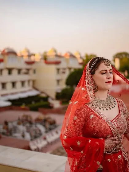 A stunning portrait of our international bride against the backdrop of the Jai Mahal Palace. The golden hour light on the palace architecture adds a magical, royal touch.