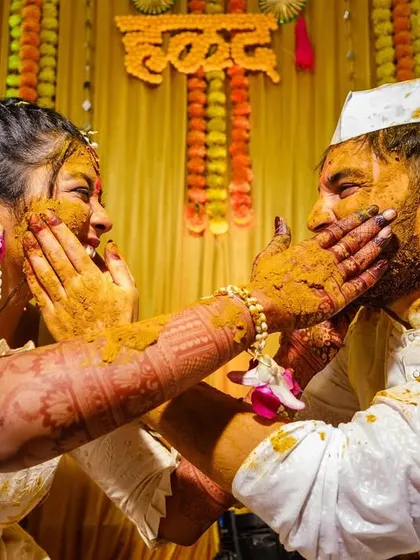 A fun and playful "haldi fight" between the bride and groom, a moment of pure, unscripted fun.