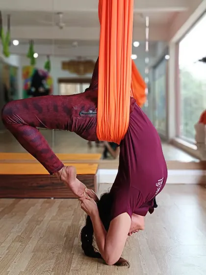 This supported backbend in the aerial hammock allows for a deep spinal extension and shoulder opening, a key benefit of anti-gravity yoga.