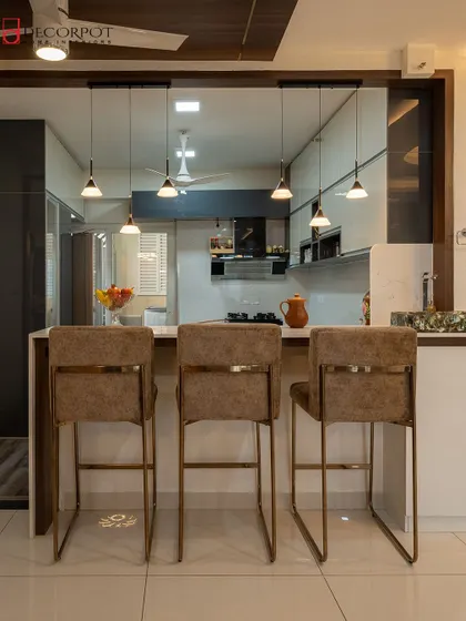 This kitchen features a stylish breakfast bar with elegant seating, seamlessly connecting the kitchen to the living area. The pendant lights add a touch of sophistication, making it a perfect spot for casual meals or morning coffee.