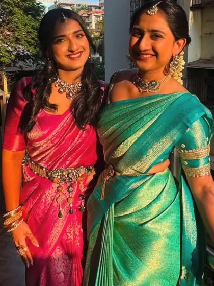 A lovely photo of the two sisters together, showcasing their coordinated outfits. My group draping service ensures that everyone in the family can have a consistent and polished look for the wedding.