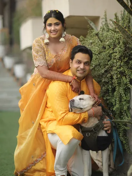 The couple poses with their beloved dog, making sure their furry family member is part of the celebration.