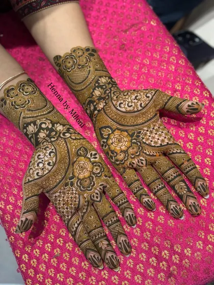 This bridal henna combines bold, dark-stained floral patterns with fine, intricate checkwork, creating a beautiful contrast on the hands.