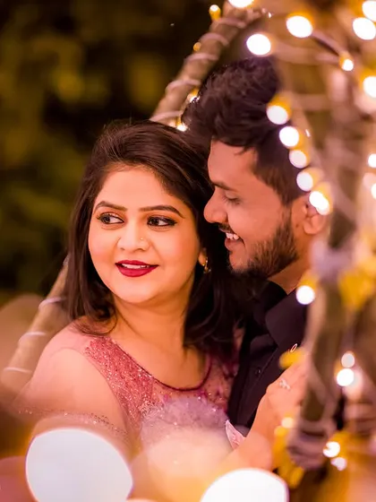 A beautiful close-up of a couple enjoying a moment together, surrounded by the enchanting glow of fairy lights. The focus is on their genuine smiles and connection.