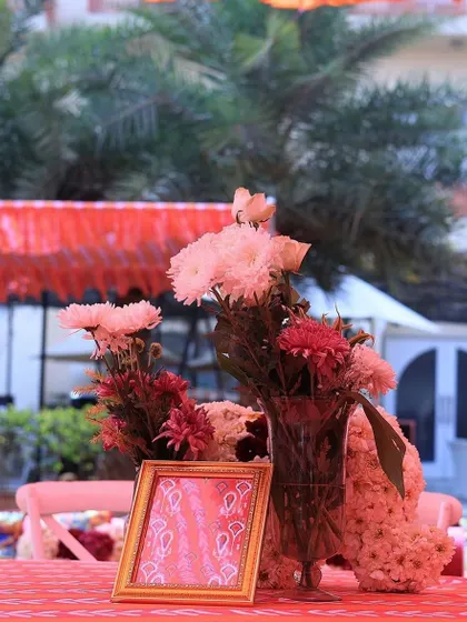 A close-up of a table centerpiece at the red and orange themed Mehendi, showing the attention to detail in every aspect of the decor.