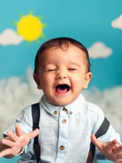 The purest joy. This baby's wide-open laugh is infectious. The simple, bright background keeps all the focus on his happy expression.