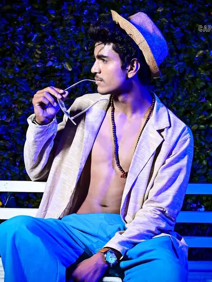 A stylized male fashion portrait taken during an outdoor event. The cool-toned lighting and fashionable attire create a trendy, high-fashion look perfect for a model's book or event coverage.