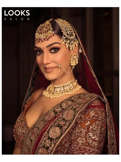 This bride exudes confidence with her glamorous makeup look. The defined, smokey eyes and contoured features are balanced with a neutral lip, allowing her natural beauty and stunning jewelry to shine.
