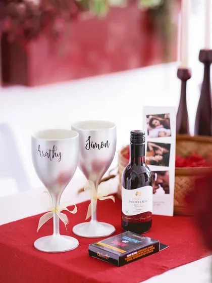 A close-up of the personalized wine glasses and wine bottle, the centerpiece of this romantic hamper.
