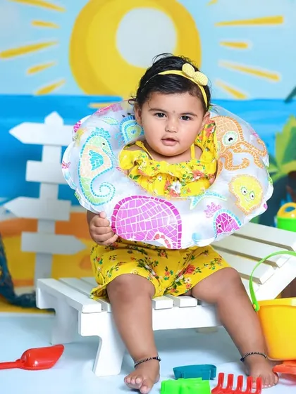 Ready for a swim. Aarna looks adorable with her floatie during her fun and sunny beach-themed first birthday shoot.