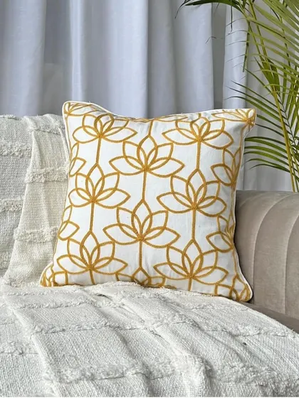 Our lotus cushion cover styled on a sofa, showing how it can instantly elevate the look of your furniture with its sophisticated pattern.