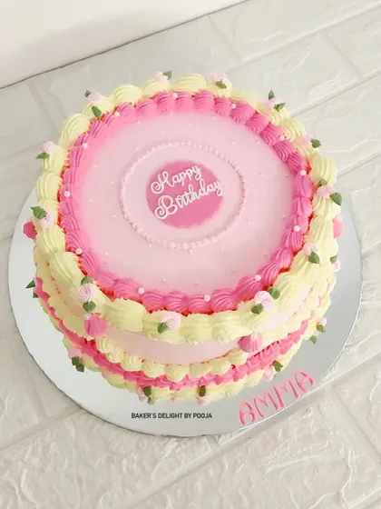 A vintage-inspired cake for a 90th birthday. The delicate pink and yellow piping and handcrafted flowers give it a timeless and elegant feel, perfect for celebrating a long and beautiful life.