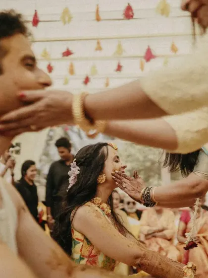 A mother lovingly applies Haldi to the bride and groom, a heartwarming moment from the ceremony.