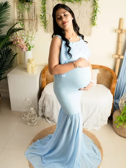 A classic standing portrait in a form-fitting blue mermaid-style gown. This style is perfect for elegantly showcasing the baby bump.