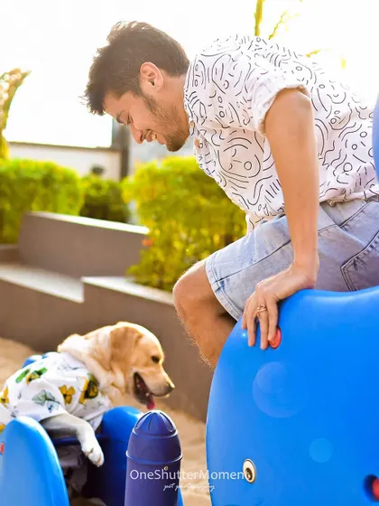 Sunsets, sand, and playgrounds bring out the kid in all of us. This candid shot captures a beautiful, gentle moment between a man and his dog during a fun-filled afternoon session.