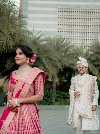 A beautiful portrait where the bride is the focus, with the groom smiling in the background. This composition creates a lovely sense of depth and story.