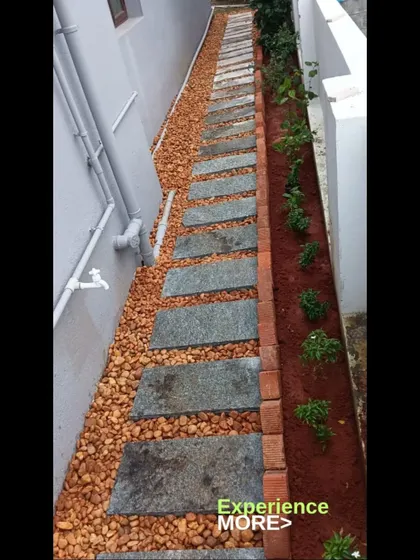 This narrow side yard was transformed with a practical stone pathway, a pebble border, and a planting bed with a brick edge.