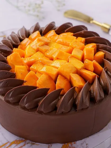 A beautiful mango and chocolate cake. Our photography highlights the contrast in colors and the generous topping of fresh mango, making it a perfect hero shot for a bakery.