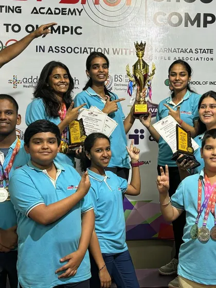 Our shooters celebrating their team victory at the Best Shot Open Competition, proudly displaying their trophy, medals, and certificates of merit.