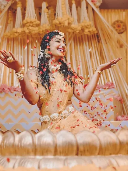 A candid moment of happiness during the Arisina Shastra. The air is filled with turmeric and flower petals, celebrating the bride in a setting I designed to be both traditional and photogenic.