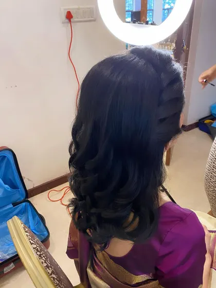 A simple yet elegant hairstyle with soft, layered curls, perfect for a wedding guest or bridesmaid.