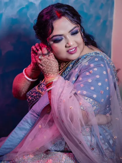 This is a beautiful reception look I created for my bride. We opted for a dramatic smokey eye and a soft pink lip, paired with a sophisticated updo to perfectly complement her blue and pink lehenga.