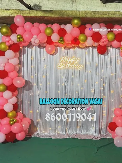 A lovely pink, red, and gold balloon arch for a first birthday. This setup is perfect for home parties, featuring a shimmer curtain, a neon sign, and a number '1' foil balloon.