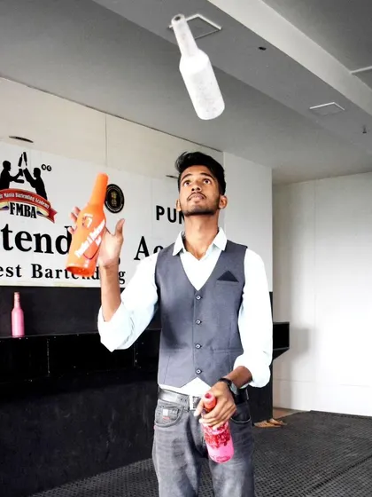 An action shot of a flair bartender juggling multiple bottles, demonstrating the dynamic entertainment we provide.