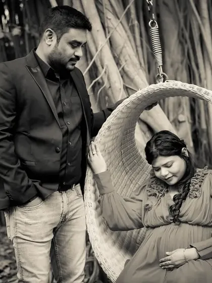 A creative and artistic black and white shot using a hanging chair as a prop. This photo has a moody and romantic feel, showcasing a different style of maternity photography.