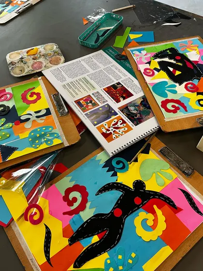 A table full of Matisse-inspired collages, showing the beautiful results of his "drawing with scissors" technique.