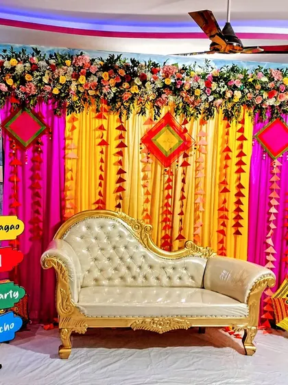 A colourful and festive floral decoration for a Mehendi ceremony. We used bright pink and yellow drapes, fresh flower arrangements, and fun props to create a lively party atmosphere.