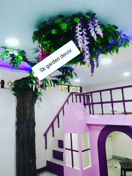 This is an artificial tree I built indoors, with branches that spread across the ceiling. The hanging purple wisteria flowers and integrated lighting create a magical, whimsical effect, perfect for a kids' room or a themed cafe.