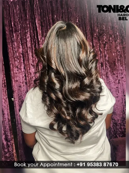 The perfect blowout on freshly colored hair. This image showcases the incredible shine and volume of a deep brunette color styled into glamorous, bouncy curls.