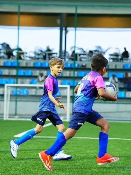 A young player holds the ball during a training game. Our sessions are designed to be fun and engaging for all age groups.