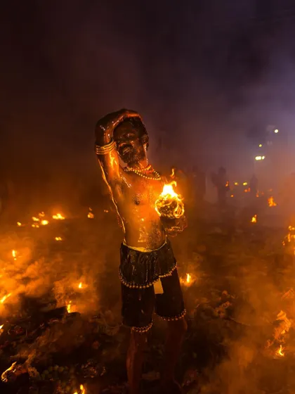 A devotee dances amidst the flames at Kulasai, his body gleaming in the firelight. This shot captures a moment of ecstatic release and spiritual fervor.