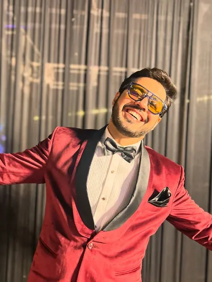 A big, happy smile that shows how much I love my job, dressed in a standout red tuxedo.
