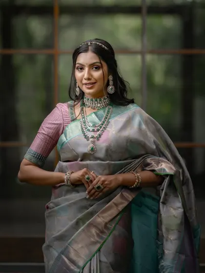 This is for the bride who seeks tradition with a touch of modern glamour. This unique Kancheevaram silk, with its blend of grey, pink, sky blue, and lavender, is a piece of wearable art designed to dazzle at any grand occasion.