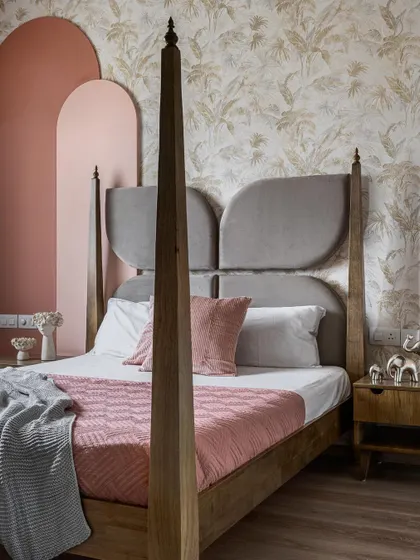 For this daughter's bedroom, we designed a custom four-poster bed with a unique, wing-shaped headboard. The color palette of soft pinks and greys, paired with a subtle botanical wallpaper, creates a room that is whimsical, elegant, and fit for a princess.