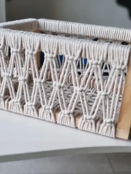 A clean shot of the empty macrame basket, showcasing the beautiful contrast between the natural wood and the off-white cotton rope.