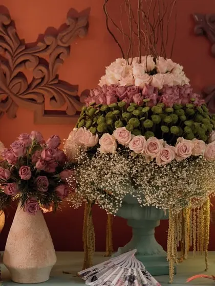 A beautiful floral display on a console table, with a mix of pink roses, baby's breath, and other blooms. The warm lighting creates a cozy and romantic evening ambiance.