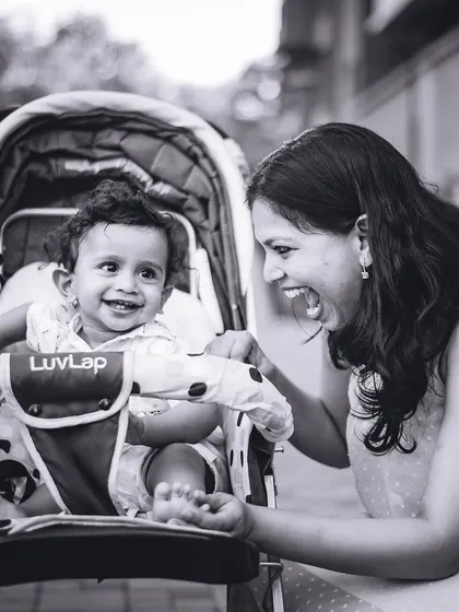 A mother and her baby share a moment of pure joy, captured in timeless black and white.