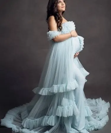 A side profile of the light blue ruffled gown, showing how the layers of tulle create a beautiful, flowing silhouette. This is a great pose to highlight the baby bump.