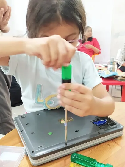 A young girl carefully disassembles a weighing scale to understand its inner workings. We encourage this curiosity and provide a safe, supervised environment for kids to explore electronics.